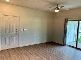 Empty living room with sliding door to balcony at High Point Preserve Apartments, Austin, TX