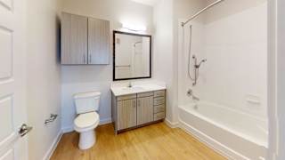 A white toilet sits next to a sink in a small bathroom at Park South Apartments, Austin, 78748