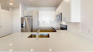 A modern kitchen with a stainless steel refrigerator and white cabinets. at Park South Apartments, Austin, TX