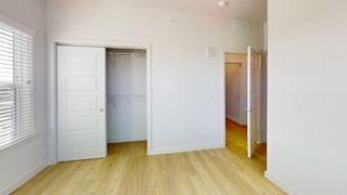 A white door is open to a room with wooden floors. at Park South Apartments, Austin