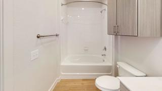 A white bathroom with a toilet, sink, and bathtub. at Park South Apartments, Texas, 78748