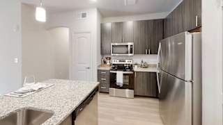 a kitchen with stainless steel appliances and granite countertops at Bridge at Three Hills Apartments, Texas, 78747