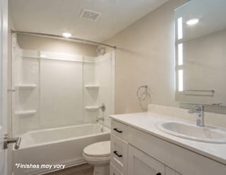 A white bathroom with a toilet, sink, and bathtub.