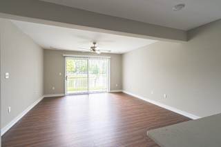 a bedroom with hardwood floors and a ceiling fan at Hillside Apartments, Wixom