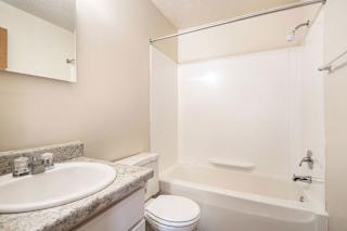 A white bathroom with a toilet, sink, and bathtub at Apple Ridge Apartments, Michigan, 49534