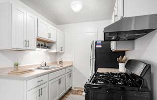 A kitchen with white cabinets and stainless steel appliances  at Apple Ridge Apartments, Walker, MI