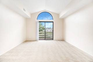 A living room with a large window and a cathedral ceiling at Arbor Lakes Apartments in Elkhart, IN
