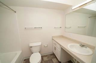 a bathroom with a sink toilet and a mirror  at Arbor Lakes Apartments, Elkhart, IN