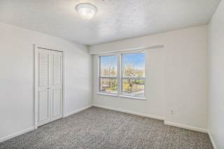 Empty bedroom with closet and carpeted flooring at Brentwood Park Apartments, La Vista, NE