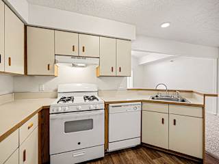 Kitchen with white cabinets and gas range at Brentwood Park Apartments, La Vista, Nebraska
