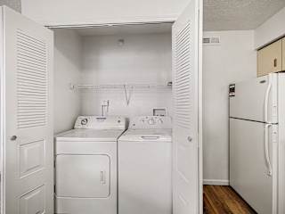 Inunit washer and dryer in closet with storage shelf at Brentwood Park Apartments, Nebraska
