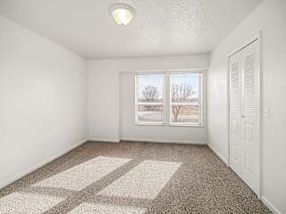Empty carpeted bedroom with dual windows and closet at Brentwood Park Apartments, Nebraska, 68128