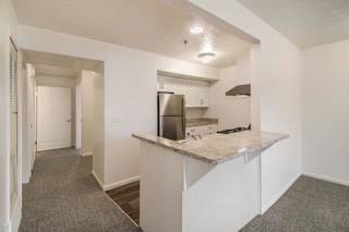 Modern kitchen with peninsula bar and stainless refrigerator at Brentwood Park Apartments, Nebraska