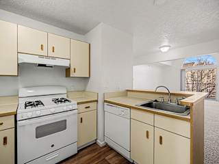Galley kitchen with white appliances and dishwasher at Brentwood Park Apartments, La Vista, 68128