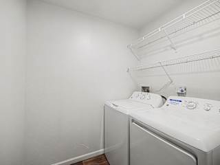Inunit laundry with wire shelving above at Brentwood Park Apartments, La Vista