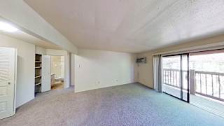 A spacious living room with a balcony at Briarwood Apartments in Benton Harbor, MI