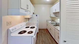 A kitchen with white cabinets and appliances at Briarwood Apartments in Benton Harbor, MI