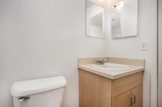Bathroom vanity with wooden cabinetry and mirror at Brookside Apartments, Springfield, MI