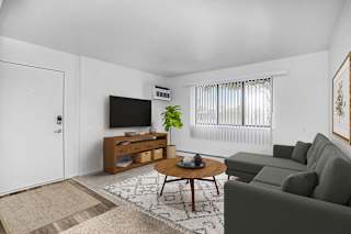 Living room with green sofa and round coffee table at Brookside Apartments, Springfield