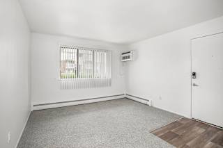 Empty carpeted room with window at Brookside Apartments, Michigan