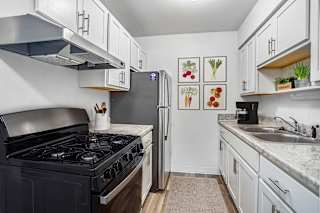 Galley kitchen with white cabinets and gray countertops at Brookside Apartments, Michigan, 49037