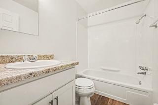 Bathroom with granite vanity and tub shower combo at Brookside Apartments, Michigan