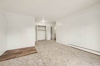 Empty bedroom with closet and baseboard heating at Brookside Apartments, Springfield, MI