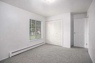 Spacious carpeted bedroom with double closet at Brookside Apartments, Springfield, MI 49037