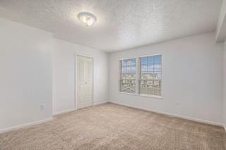 Empty carpeted bedroom with closet and windows at Black Sand Apartments Homes, Lincoln
