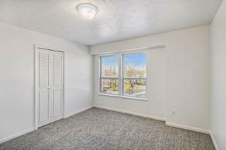Bedroom with large windows and a door to a closet at Canal 2 Apartments in Lansing, MI