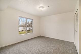 large bedroom with a window and carpet at Canal 2 Apartments in Lansing, MI