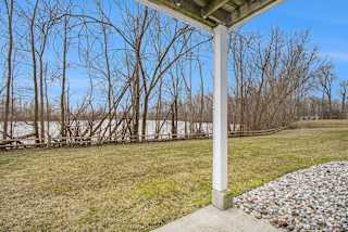 a patio with a view of a pond and trees at Canal 2 Apartments in Lansing, MI