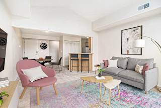 A living and dining room with a grey couch at Canal Club Apartments in Lansing, MI