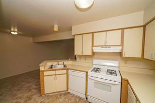 A kitchen with a white gas stove and dishwasher at Canal Club Apartments, Michigan