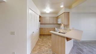 Galley kitchen with peninsula breakfast bar at Colonial Pointe at Fairview Apartments, Bellevue, Nebraska