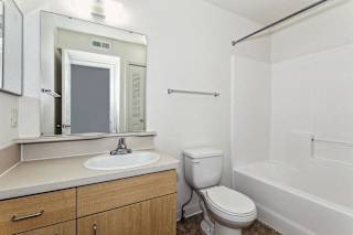 Bathroom with tub shower combo and large mirror at Colonial Pointe at Fairview Apartments, Bellevue