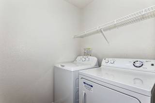 In unit washer and dryer with overhead shelving at Colonial Pointe at Fairview Apartments, Bellevue, Nebraska
