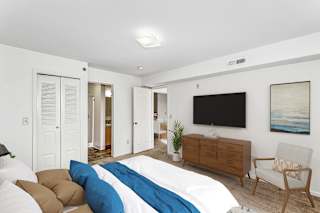 Bedroom with wall mounted tv and wood media console at Colonial Pointe at Fairview Apartments, Bellevue, 68123