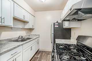 An upgraded kitchen with white cabinets and stainless steel appliances at Concord Place Apartments, Kalamazoo, 49009black gas stove.