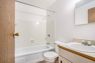 A bathroom with a bathtub/shower, vanity with sink, and toilet at Concord Place Apartments, Kalamazoo, MI