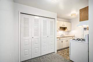 A kitchen with white appliances and wooden cabinets at Concord Place Apartments, Kalamazoo, MI