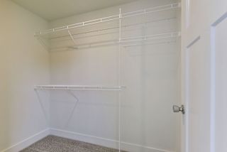 Walk in closet with wardrobe organizers at Copper Creek Apartment Homes, Maize