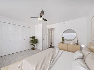 Spacious bedroom with ceiling fan and modern dresser at Copper Creek Homes Apartments, Maize, KS 67101