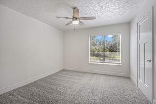 large bedroom with a ceiling fan and a window at The Crossings Apartments, Michigan, 49508