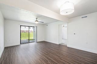 living room with hard surface flooring and a sliding glass door to a patio at The Crossings Apartments, Michigan, 49508