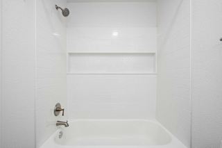 A white bathroom with a tub and shower at The Crossings Apartments, Grand Rapids