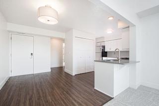 A kitchen and dining area with white cabinets and a hard-surface floor at The Crossings Apartments, Grand Rapids