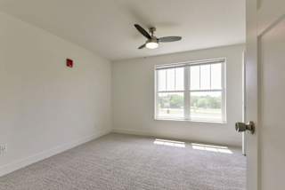 A spacious bedroom with large windows and a ceiling fan at Dodson Pointe Apartment Homes, Rogers, AR, 72758