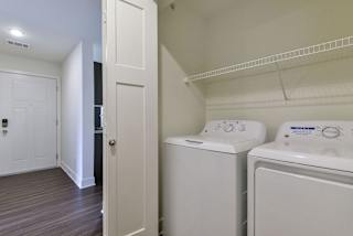 A laundry area with a full-size washer and dryer at Dodson Pointe Apartment Homes, Rogers