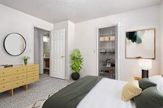A bedroom with a large bed and a walk-in closet at Dupont Lakes Apartments, Fort Wayne